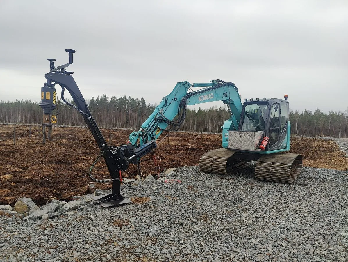Excavadora con pescante de extensión instalando pilotes helicoidales